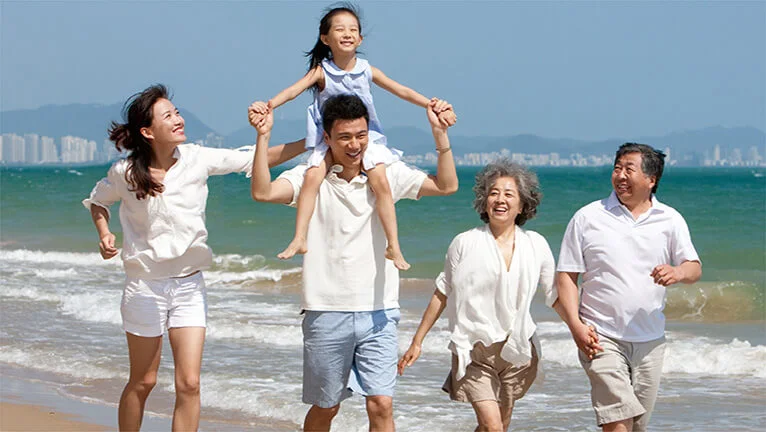 Multi generation family playing on beach 